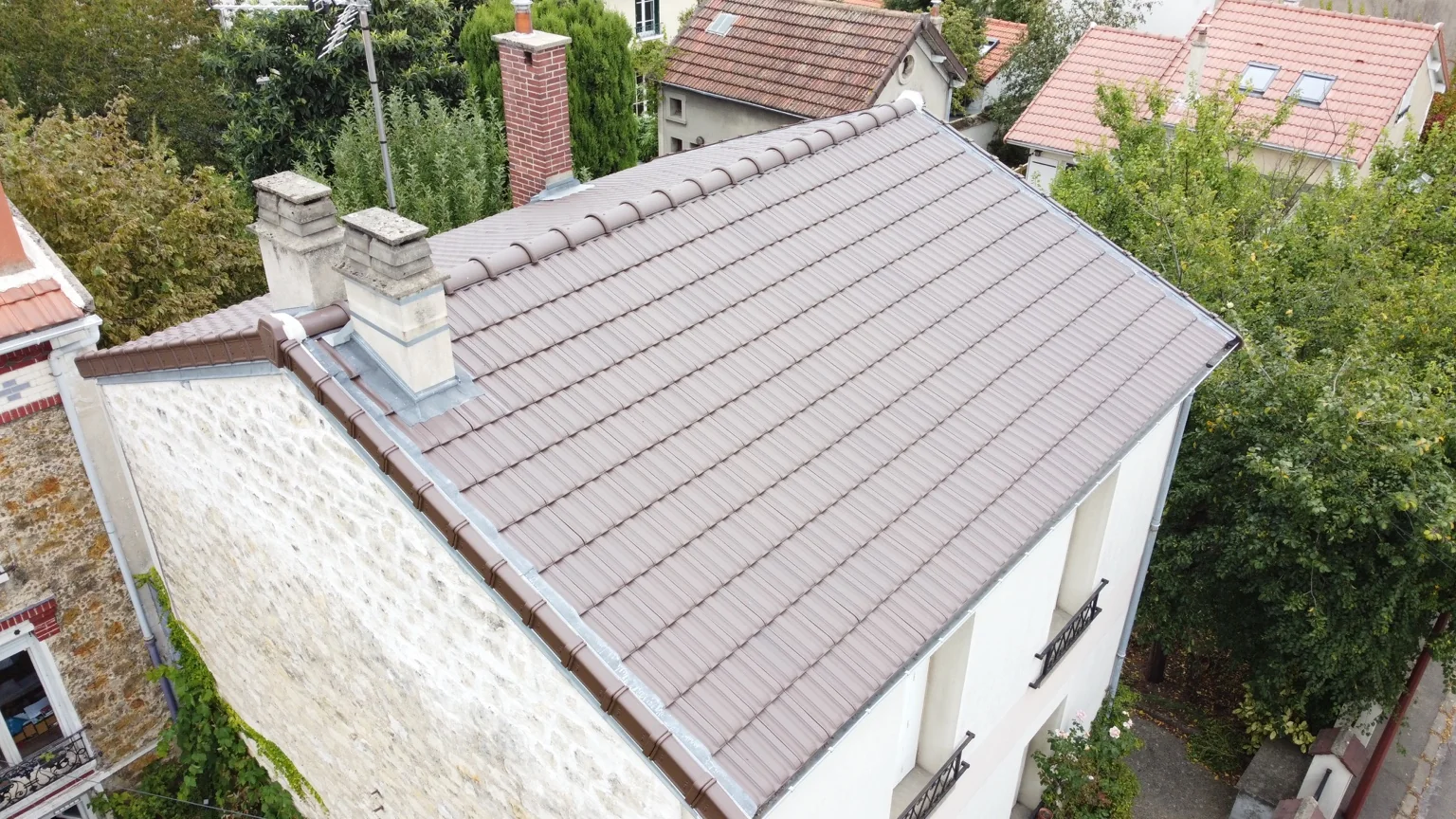 Vue aérienne d’une toiture en tuiles avec plusieurs souches de cheminée dans l’Oise