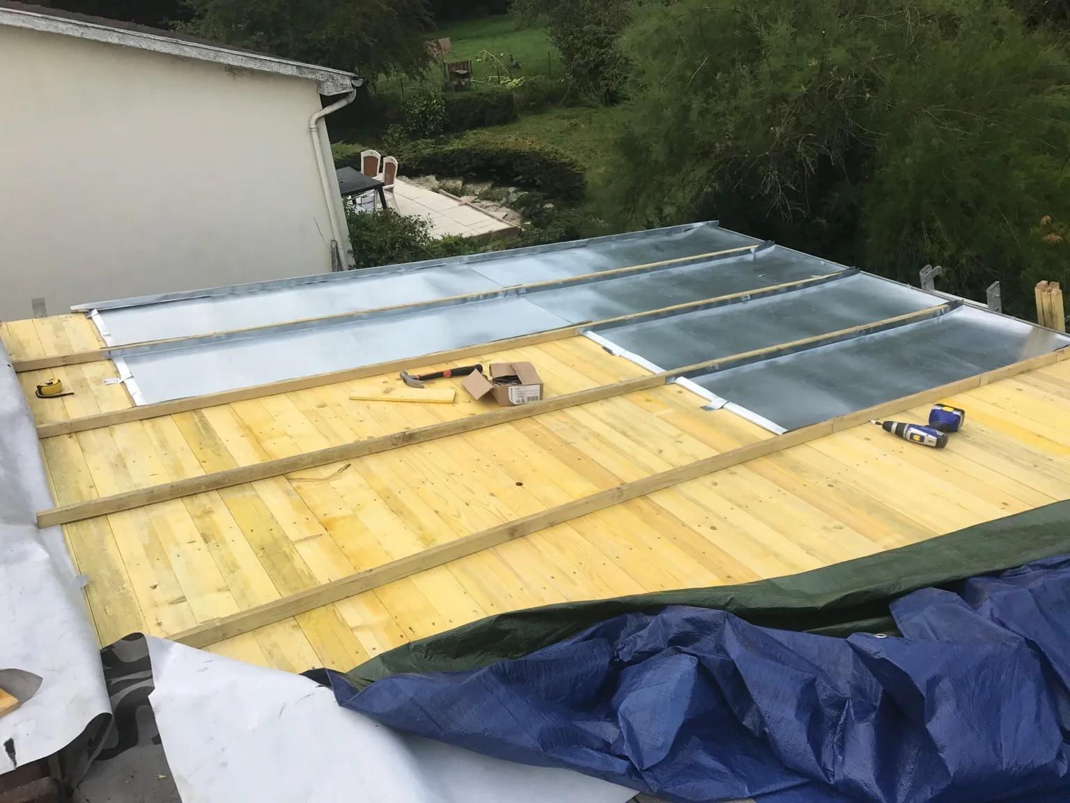 Panneaux de couverture métallique d’aspect zinc en cours de pose sur le support bois dans l’Oise