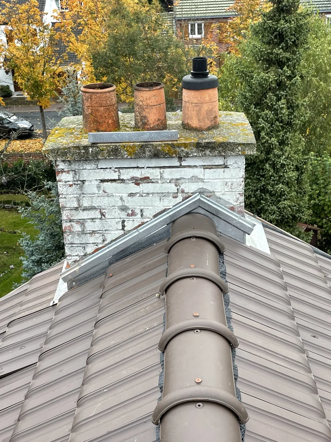 Vue distincte d’un faîtage en tuiles et d’un raccord autour d’une cheminée dans l’Oise